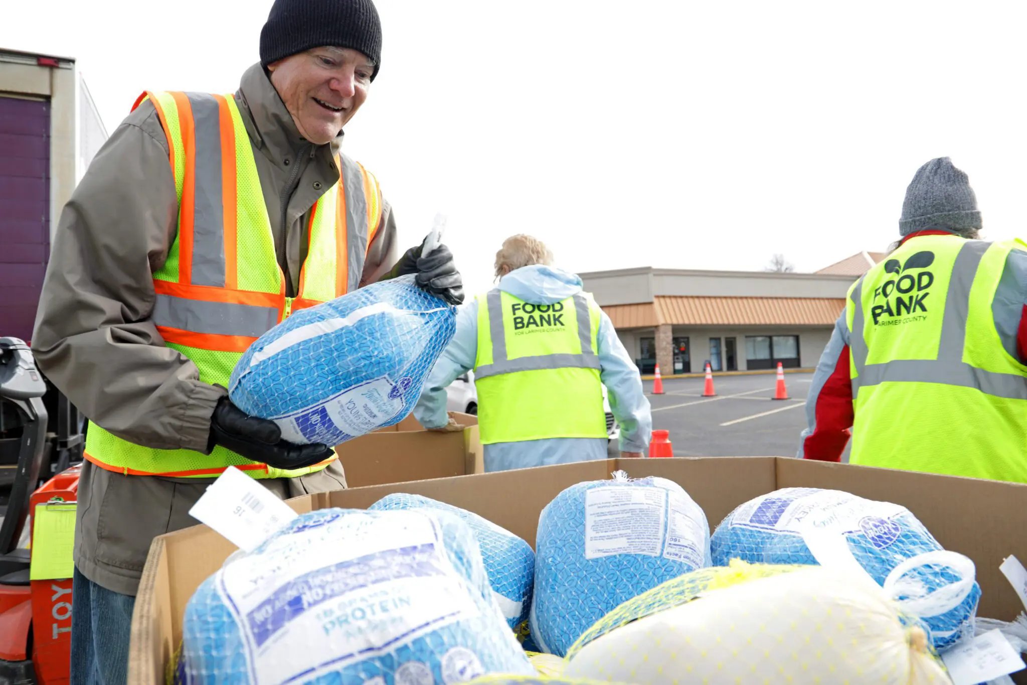 Food Bank for Larimer County Tour De Turkey Food Drive Volunteer Holding Frozen Turkey
