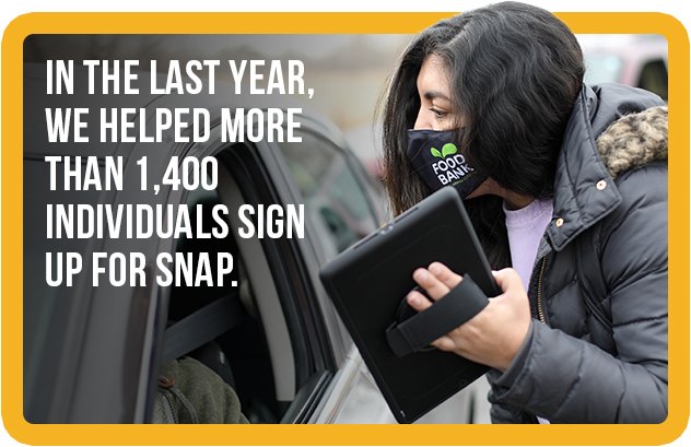 Image of a Food Bank employee assisting a client in signing up for SNAP benefits.