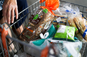 Image of a full shopping cart of food at the Food Bank.